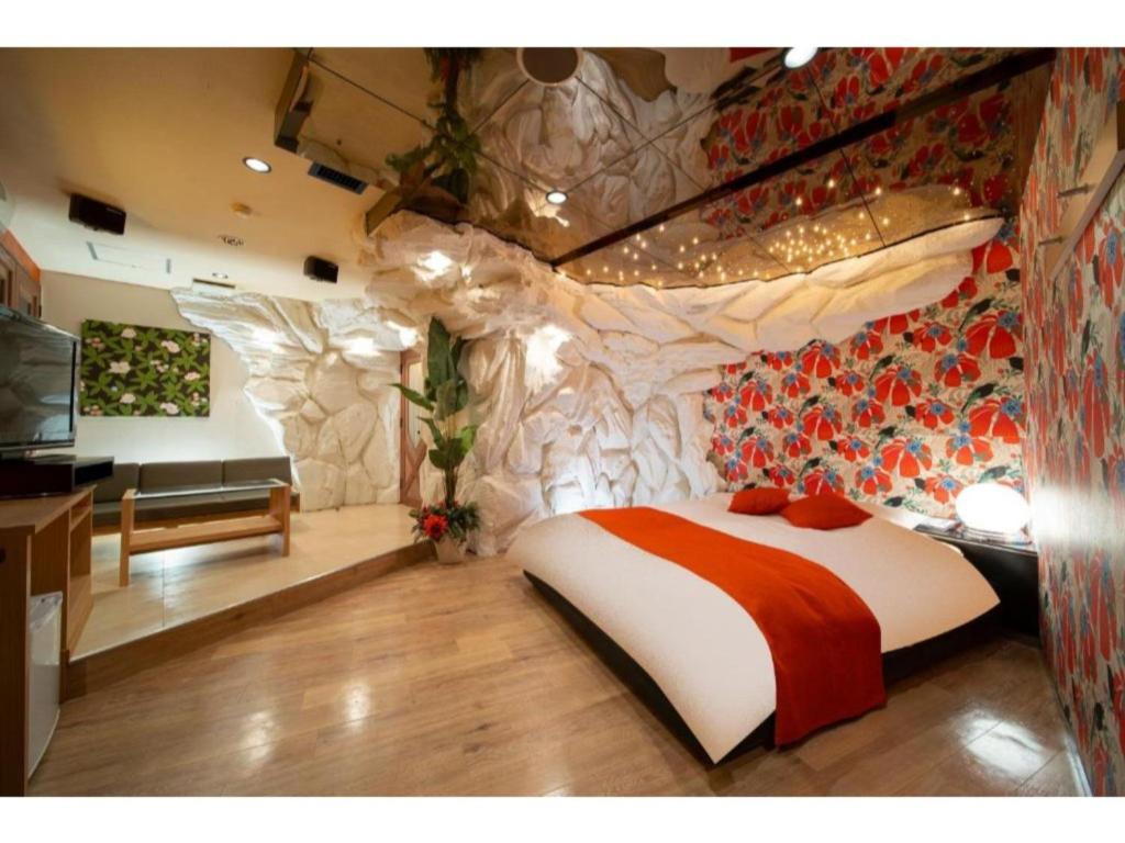 大垣Royal Hotel Uohachi Bettei - Vacation STAY 81417的一间卧室设有一张床和石墙