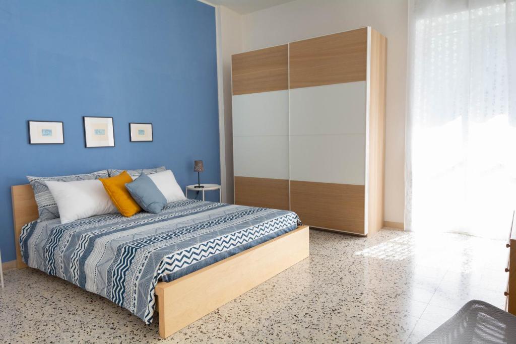萨莱诺Gaia14的一间卧室设有一张床和蓝色的墙壁