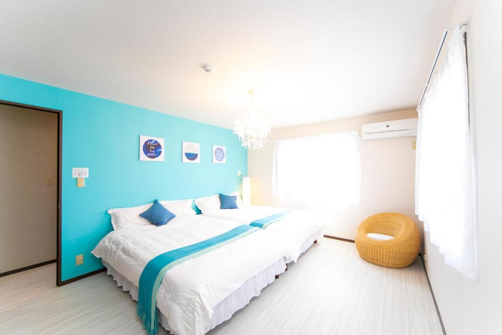 IkuhaAwaji Seaside Resort in Ikuha的一间卧室设有一张蓝色墙壁的大床