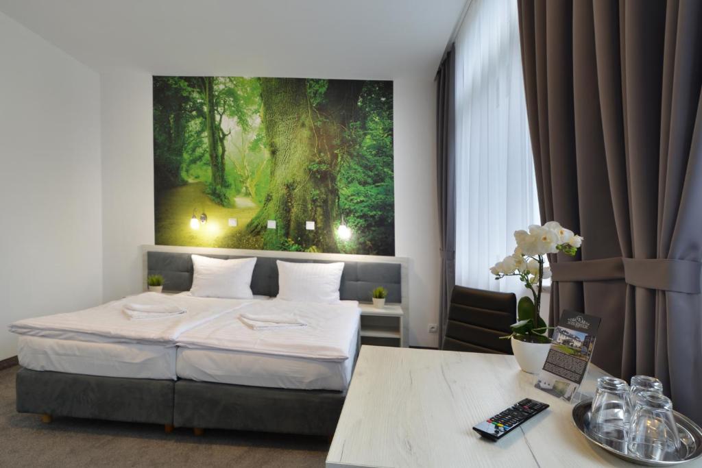 兹维日涅茨Hotel Roztocze的卧室配有一张床,墙上挂着一幅大画