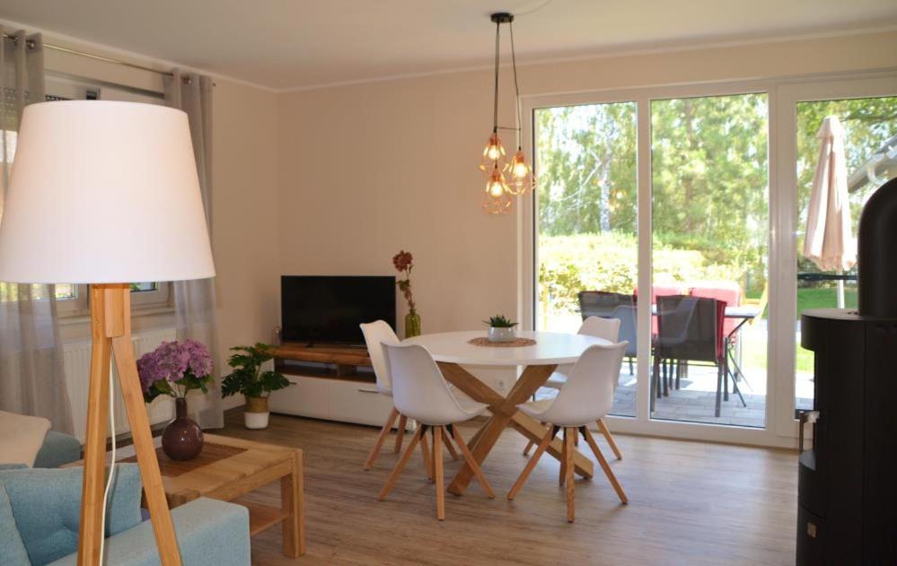 马林费尔德U17 EG - komfortable Ferienwohnung mit Terrasse, Wlan und Kamin的客厅配有桌椅和电视。