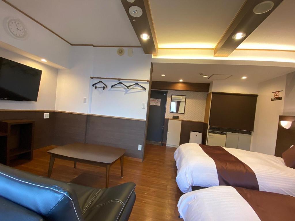 广岛藤田赛久酒店的酒店客房设有两张床和一台平面电视。