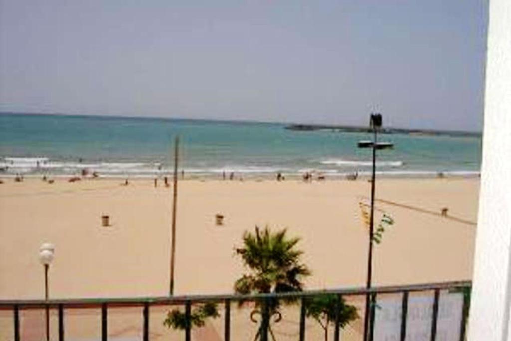 巴尔巴特3 bedrooms apartement at Barbate 100 m away from the beach with sea view and furnished terrace的和水中的人一起欣赏海滩的景色