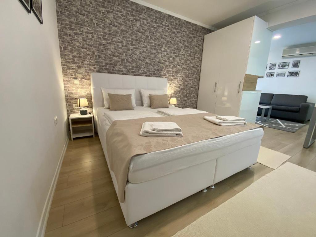 莫斯塔尔Apartments & Rooms Mostar Story的卧室配有一张白色大床