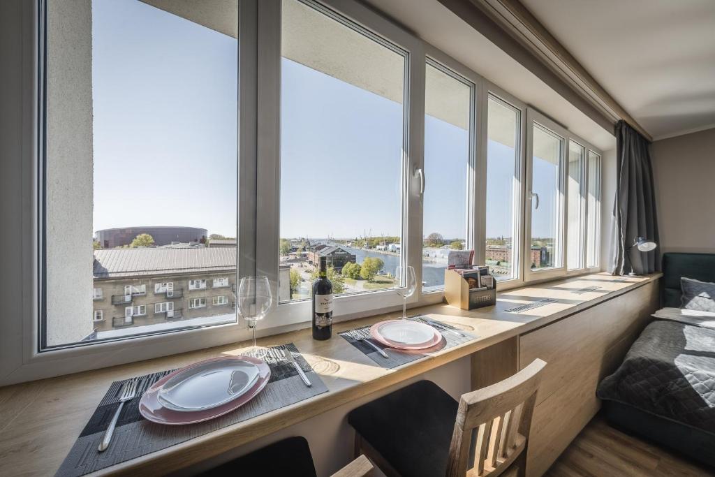 利耶帕亚Best View In Apartment的一间设有大窗户和桌椅的用餐室