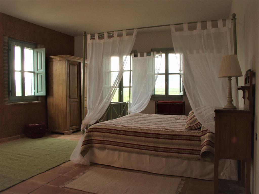 La Font D´En CarròsHotel Boutique Moli El Canyisset的卧室配有一张带白色窗帘的大床