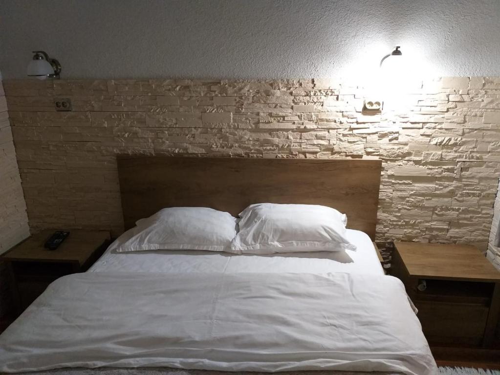 比斯特里察Raphaela Residence的卧室配有白色的砖墙床