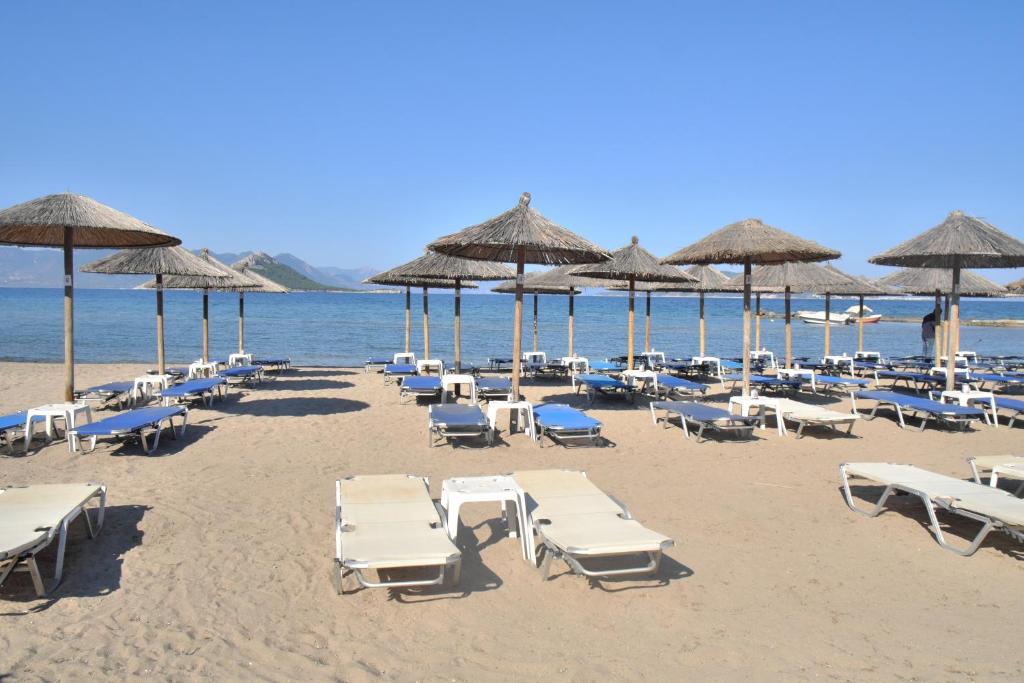爱琴娜岛Marathona's Apartment的海滩上设有椅子和遮阳伞,还有大海