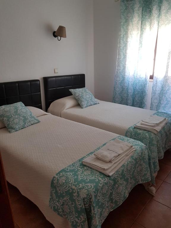 科武港Quartos Abelha的一间卧室配有两张带毛巾的床