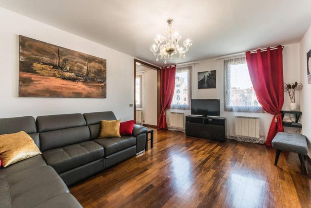 威尼斯Rialto apartment with Canal Grande view的带沙发和红色窗帘的客厅