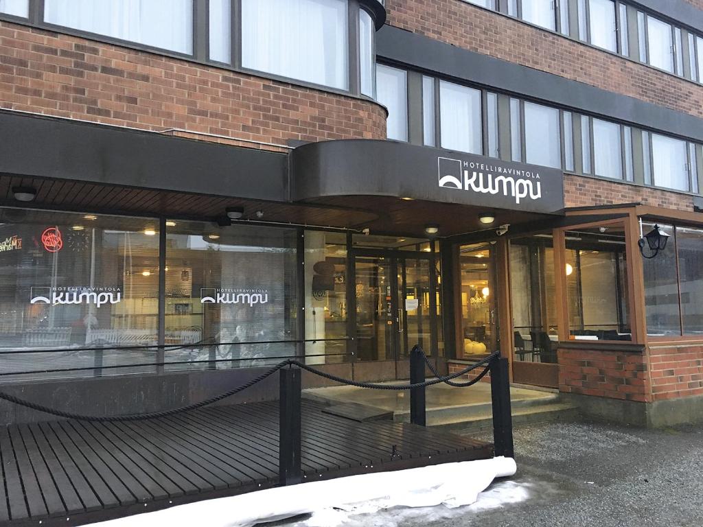 OutokumpuHotelliravintola Kumpu的砖楼前的商店,有窗户