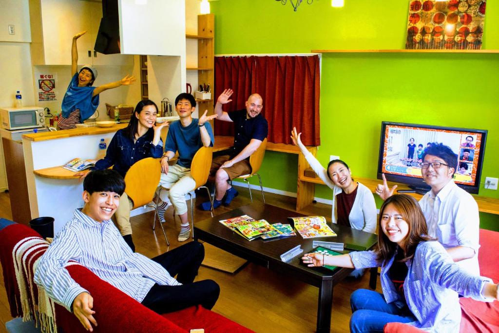 高知ゲストハウス ルルル 最大12名可 合宿 大家族 団体旅行にオススメ的一群人手举着坐在房间里