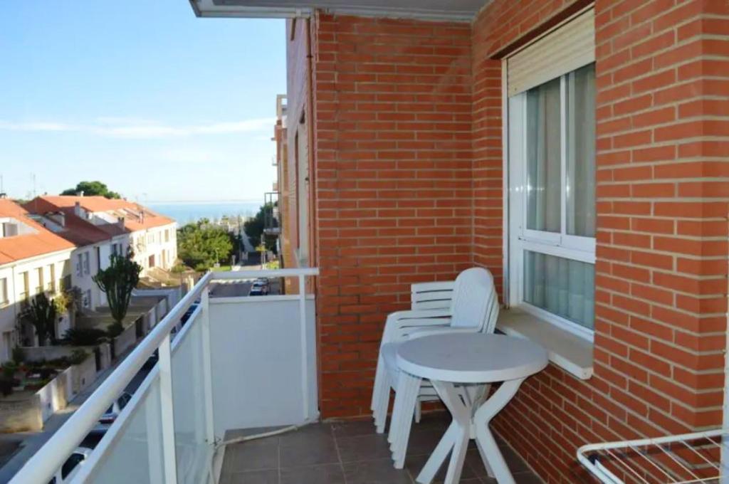 圣卡洛斯拉腊皮塔2 bedrooms apartement at Sant Carles de la Rapita 700 m away from the beach with sea view shared pool and balcony的大楼内的阳台配有桌椅