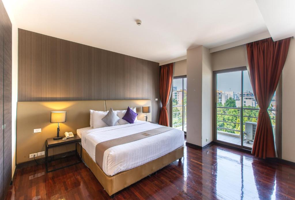 曼谷美達廊曼機場酒店的一间卧室设有一张大床和一个大窗户