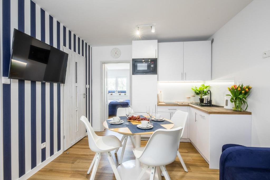 波德贝Apartament 1B Blue Marine Poddąbie的厨房以及带桌椅的用餐室。