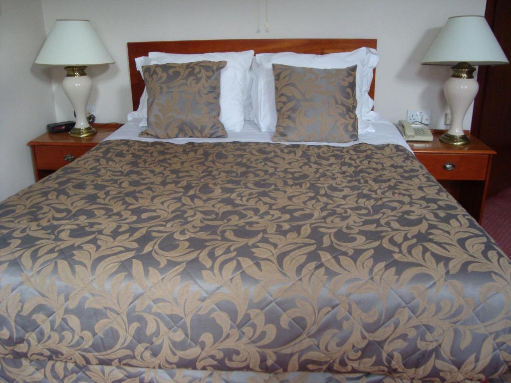 希钦费斯酒店的一张位于酒店客房的床位,配有两盏灯