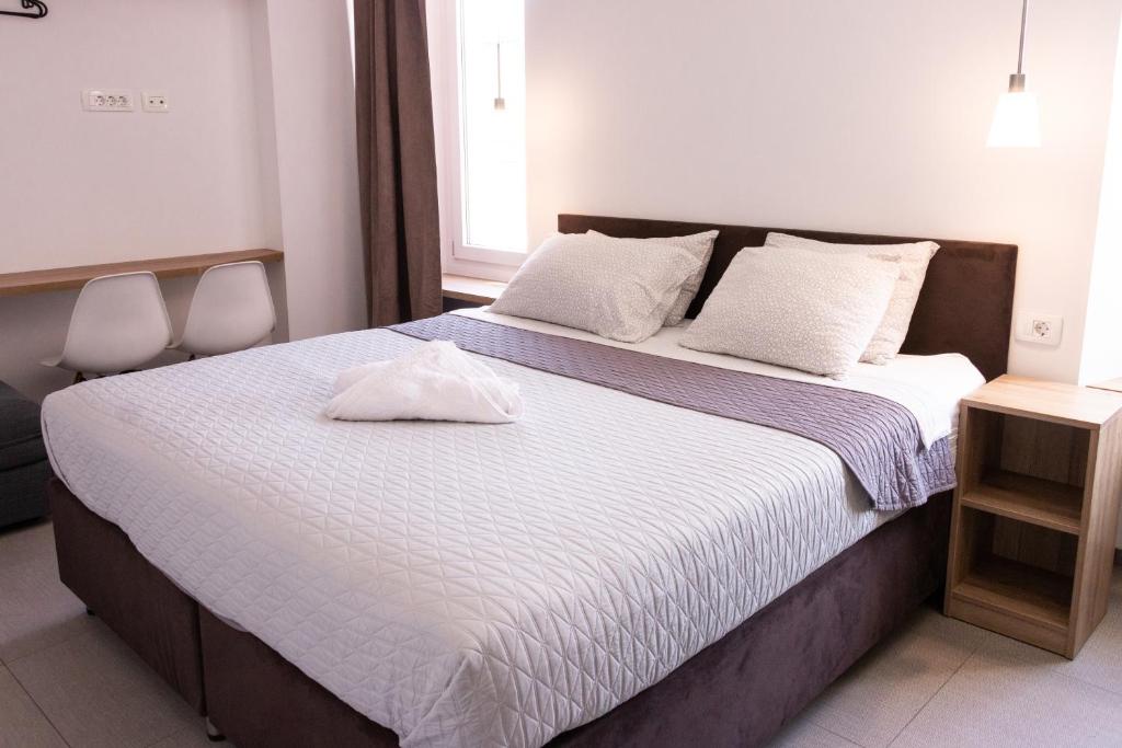 科佩尔穆赛慕旅舍的一间卧室配有一张带白色床单的大床