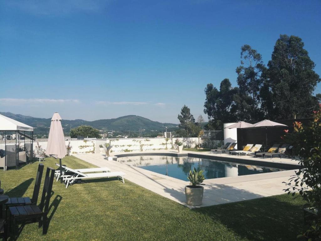 阿马里什Casa d'Amares的一个带草坪椅和遮阳伞的游泳池