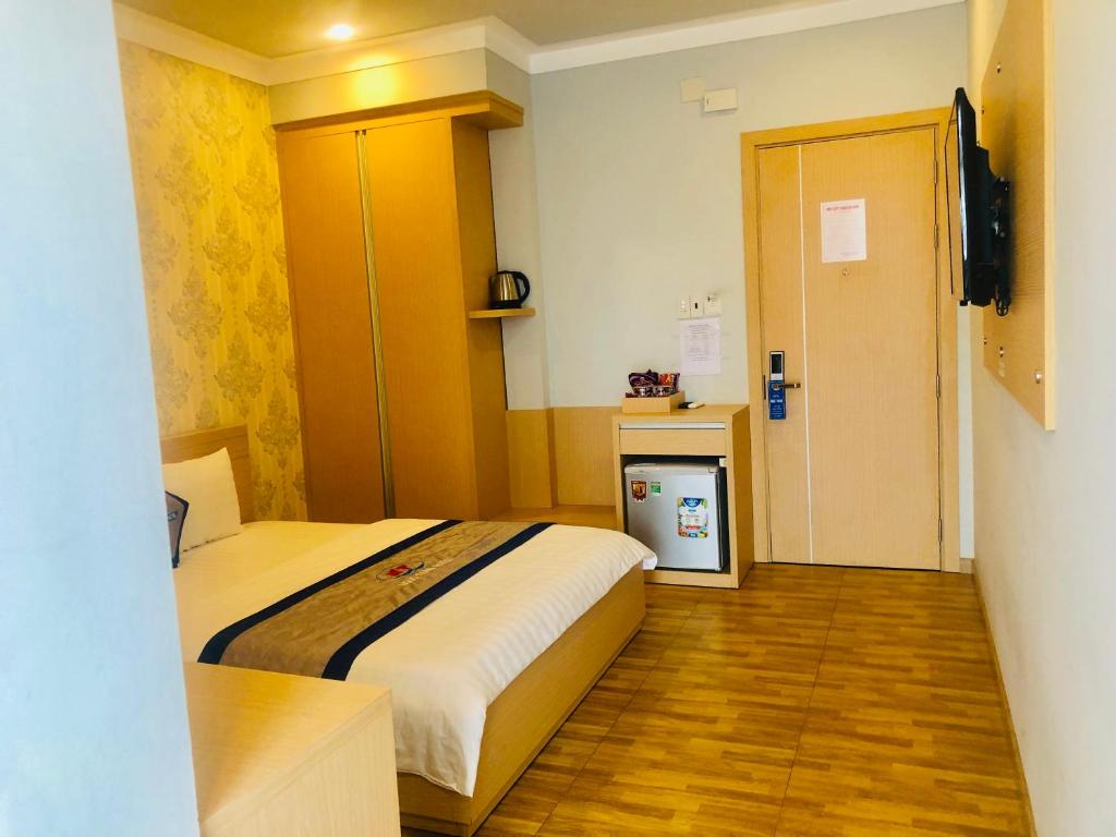 迪石Ngoc Thanh Hotel的酒店客房设有一张床和一个小厨房