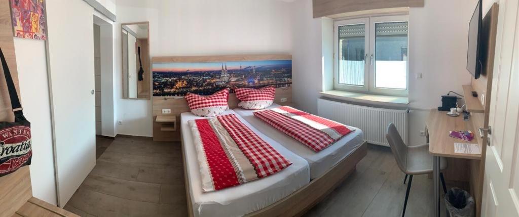 普尔海姆Abtei Apartment Brauweiler的一间卧室配有一张带红色和白色枕头的大床