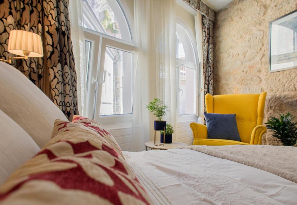 穆罗斯Casa del ancla的一间卧室配有床、黄色椅子和窗户