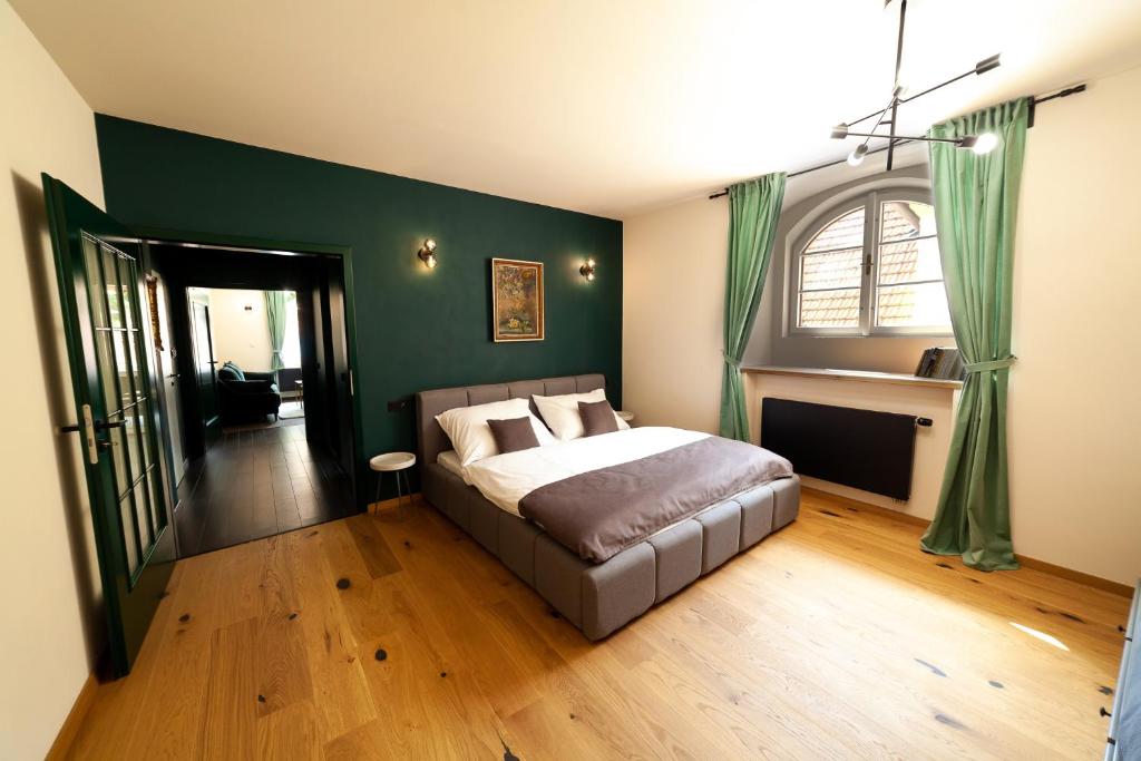 库特纳霍拉Apartmány Dačický 1的一间卧室设有一张床和绿色的墙壁