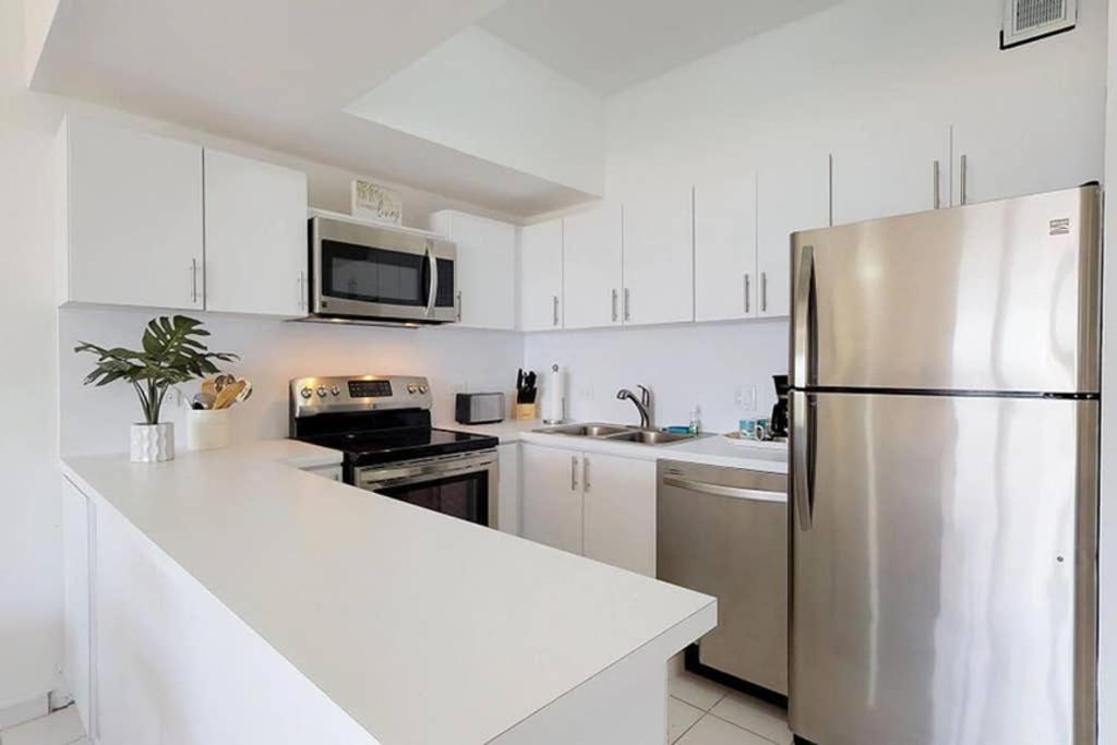乌马考Beach Villa 233的厨房配有白色橱柜和不锈钢冰箱