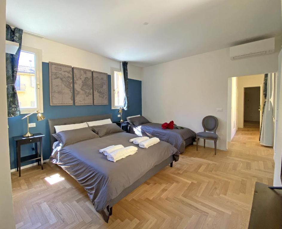博洛尼亚Residenza del Duse的配有蓝色墙壁和木地板的客房中的两张床