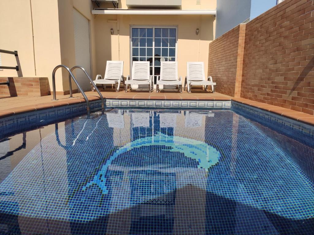 法鲁Casa das Figuras的一个带两把草坪椅的游泳池和一个游泳池