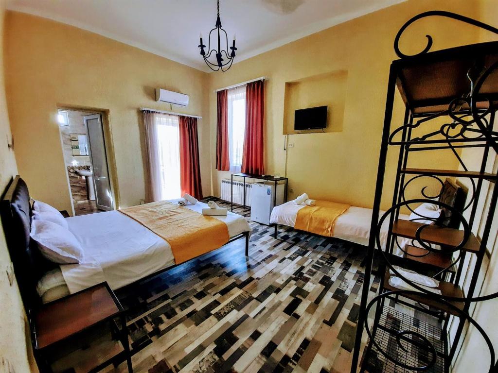 库塔伊西Green Flower Hotel的一间卧室配有两张床和一张双层床。