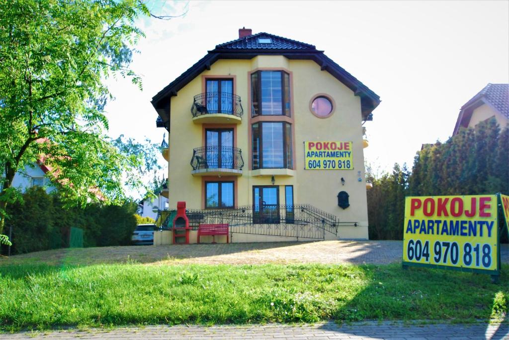 亚斯塔尔尼亚波克耶兹维多基纳摩泽2号饭店的黄色房子前面有标志