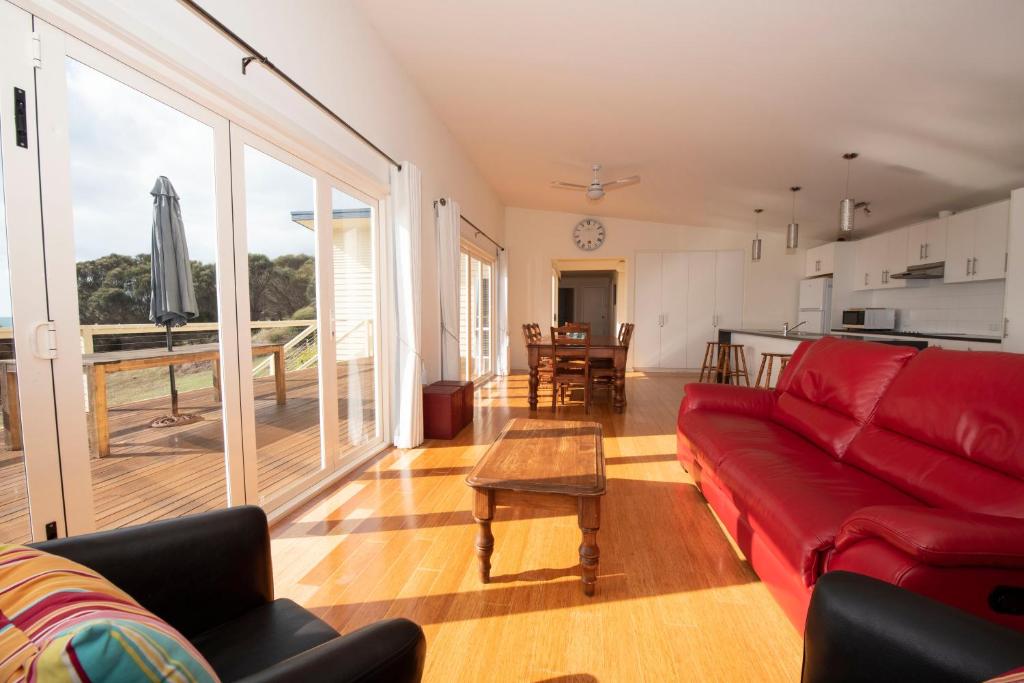 潘尼萧彭纳肖阿森登度假屋的一间带红色沙发的客厅和一间厨房