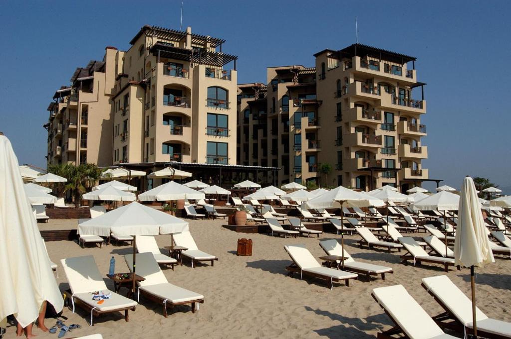 阳光海滩Apartments Oasis VIP Club的沙滩上的一把椅子和遮阳伞