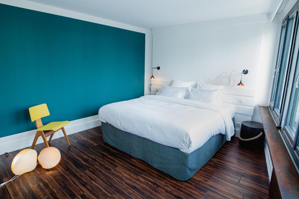 贝诺代Bateau Libre Hotel的一间卧室设有一张大床和蓝色的墙壁