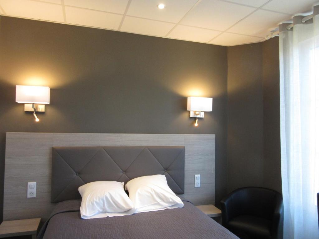 尚帕尼奥勒Hotel de la Londaine的一间卧室配有带2个枕头和2盏灯的床