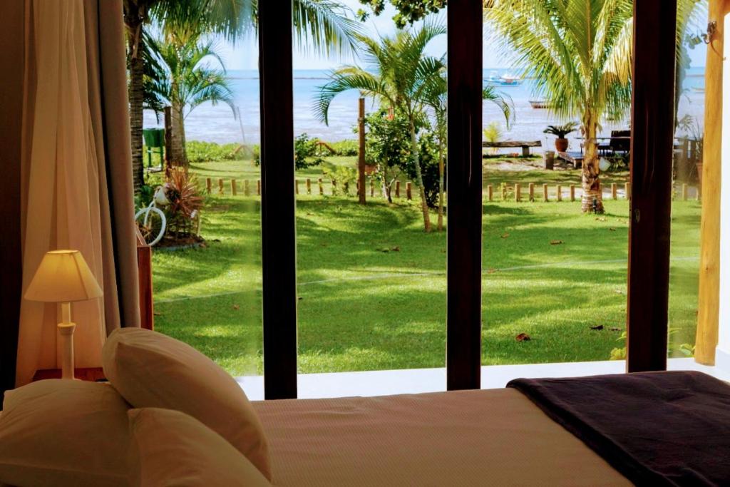 库穆鲁沙蒂巴阿瑞亚普雷塔旅馆的一间卧室设有大窗户,享有高尔夫球场的景色