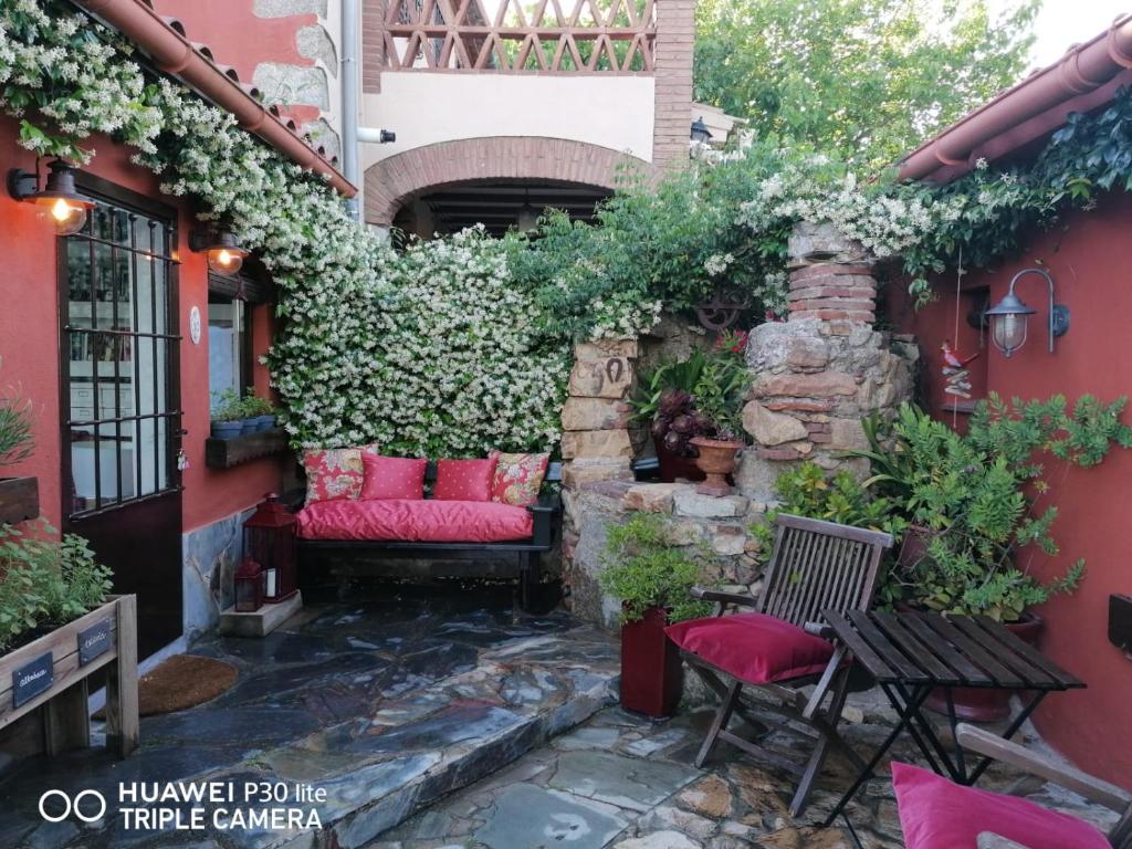 圣塔克里斯蒂纳阿鲁Suite Garden House的一个带红色靠垫和石墙的庭院