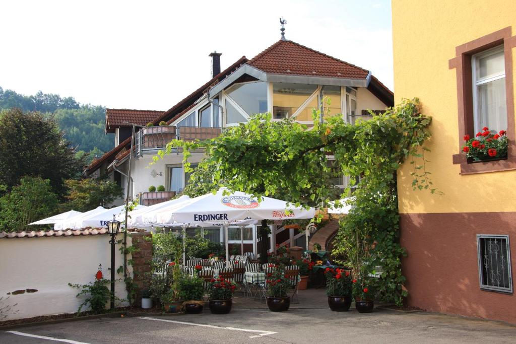 Waldfischbach-BurgalbenHotel- Restaurant Zum Schwan的一座建筑前面有雨伞和鲜花