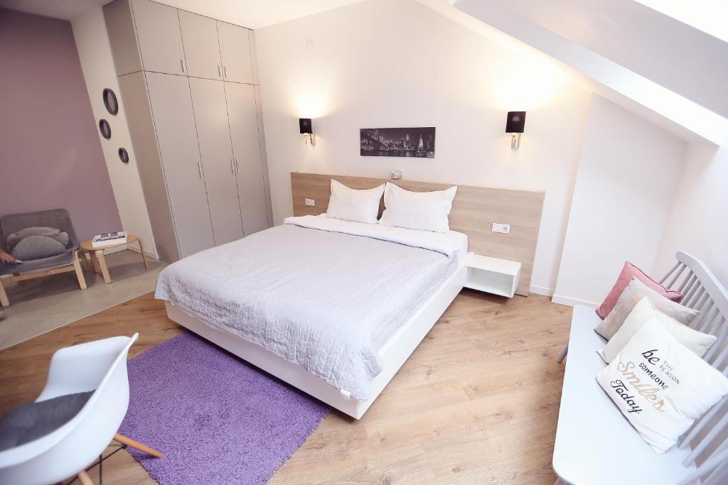 奥拉迪亚Casa M的卧室配有白色的床和紫色地毯。