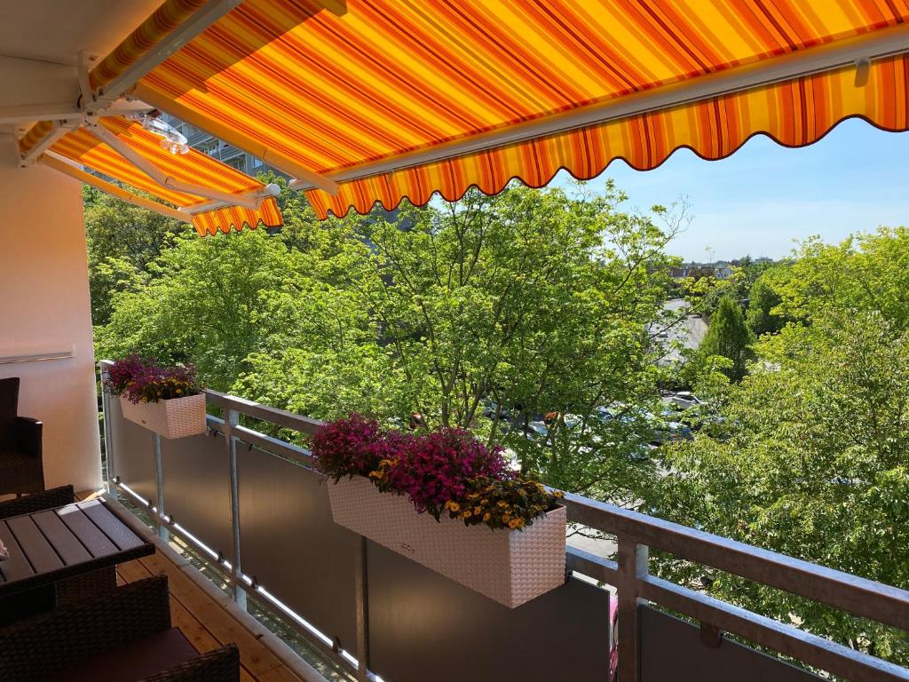 圣奥古斯丁Apartment mit Sonnenbalkon und NETFLIX im Zentrum的阳台配有两个花盒和橙色伞