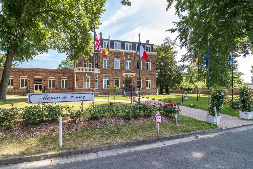科博汉姆弗斯庄园之家酒店的前面有旗帜的大砖砌建筑
