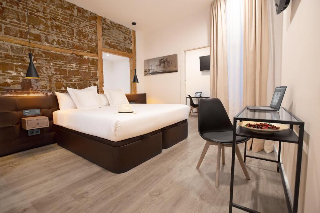 马德里Woohoo Rooms Fuencarral的酒店客房,配有床、桌子和椅子