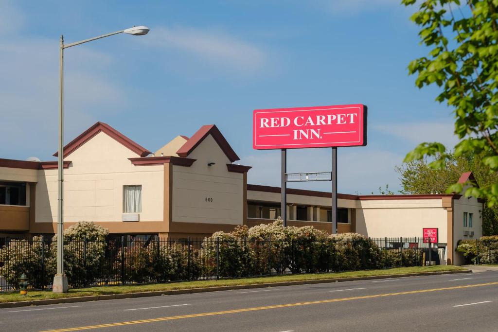 华盛顿Red Carpet Inn Washington DC的大楼前的红色车棚标志
