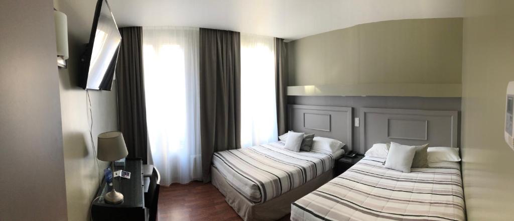 巴黎科斯莫特尔酒店的酒店客房带两张床和两个窗户