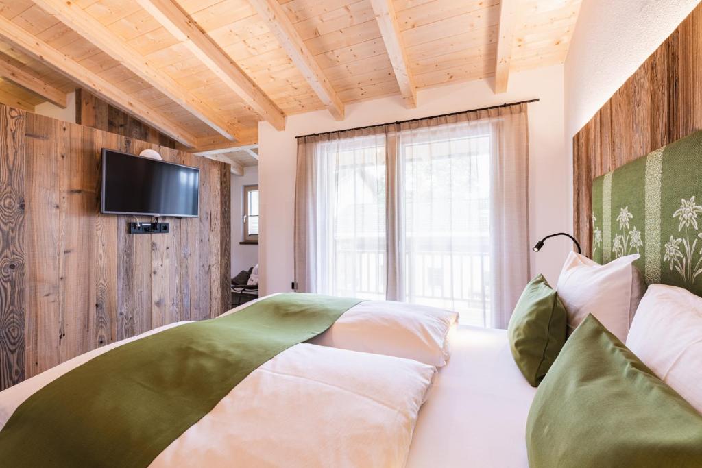 LavantMichelerhof - kinderfreie Unterkunft的一间卧室配有一张床,墙上配有电视