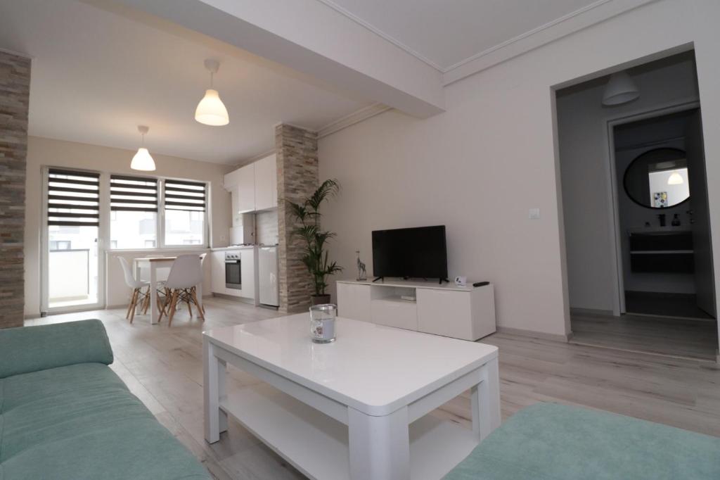 锡比乌Apartament 2 camere Anto的客厅配有白色桌子和电视