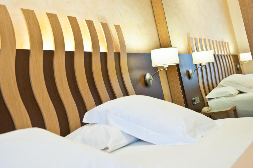 菲格拉斯Hotel Duran的酒店客房设有两张床和两盏灯。