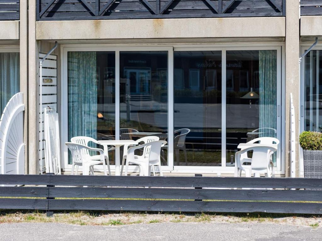 凡岛Holiday home Fanø LIII的门廊上的一组桌椅