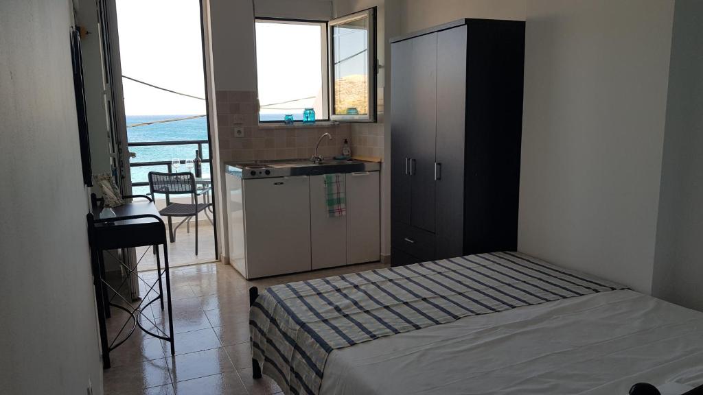 哈拉奇Porto Haraki Studios的一间卧室配有一张床,厨房配有水槽