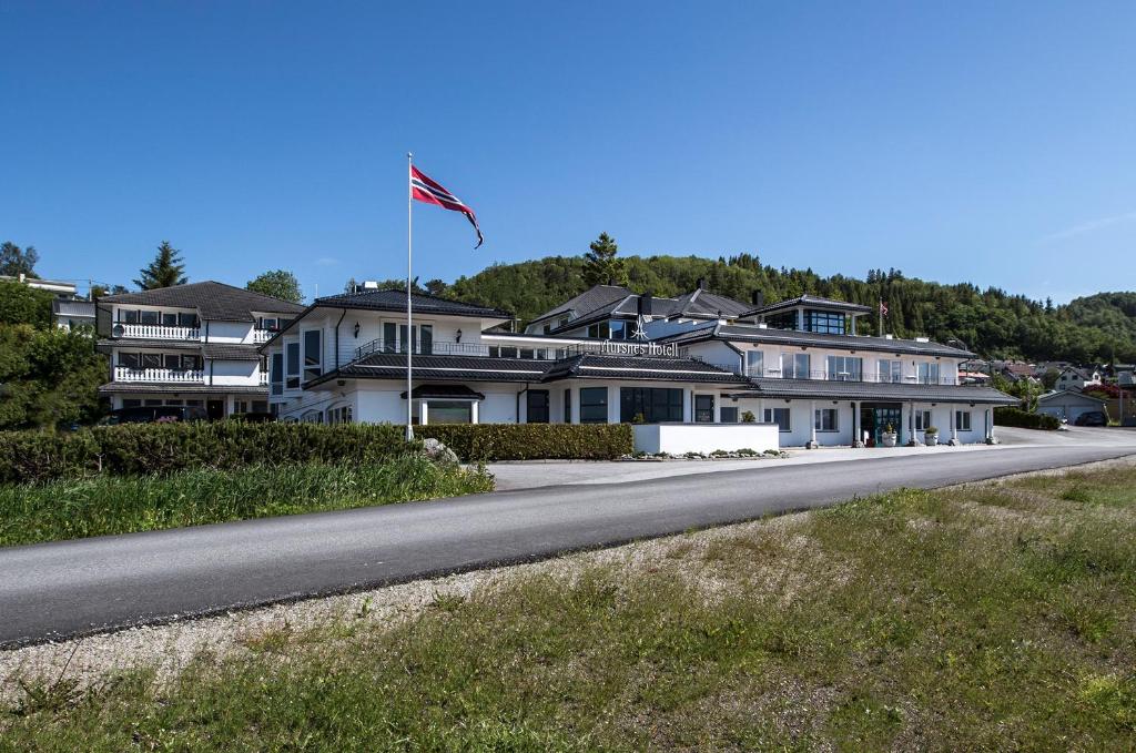 SykkylvenAursnes Hotell的路边有旗帜的房子